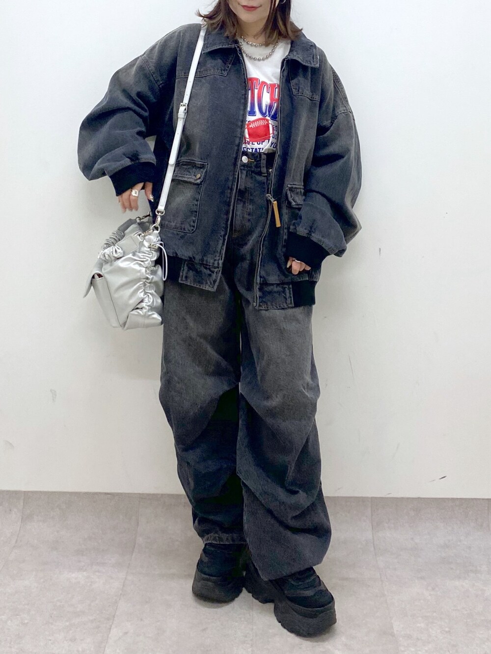 ホワイト系のTシャツ/カットソー、ブラック系のデニムジャケット、ブラック系のデニムパンツを着用したレディースの春コーディネートの3枚目の写真