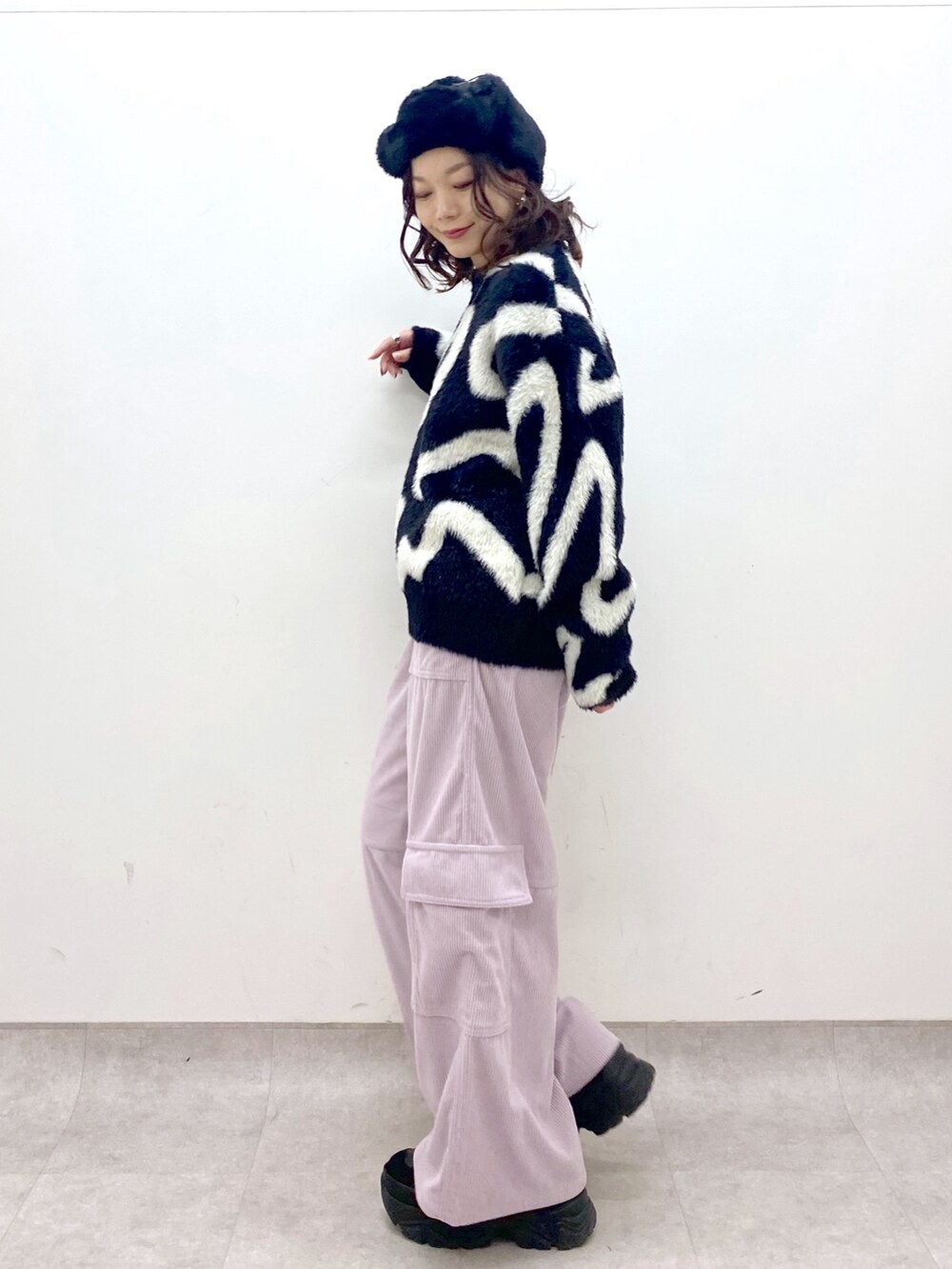 ピンク系のカーゴパンツ、ブラック系のニット/セーター、ブラック系のショルダーバッグを着用したレディースの冬コーディネートの6枚目の写真