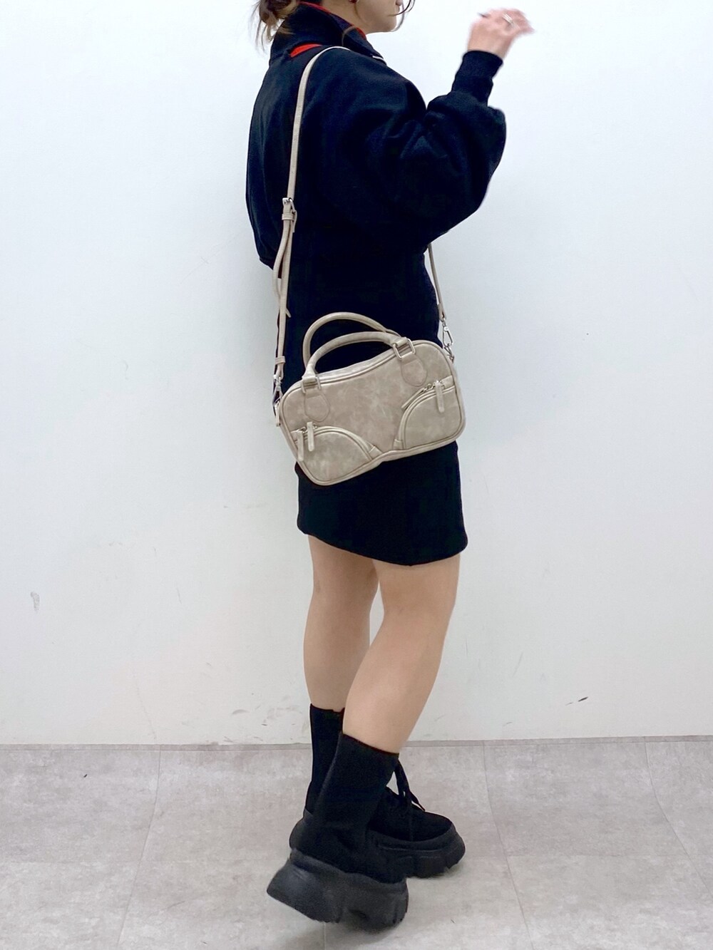 ブラック系のワンピース、レッド系のニット/セーター、ベージュ系のボストンバッグを着用したレディースの冬コーディネートの7枚目の写真