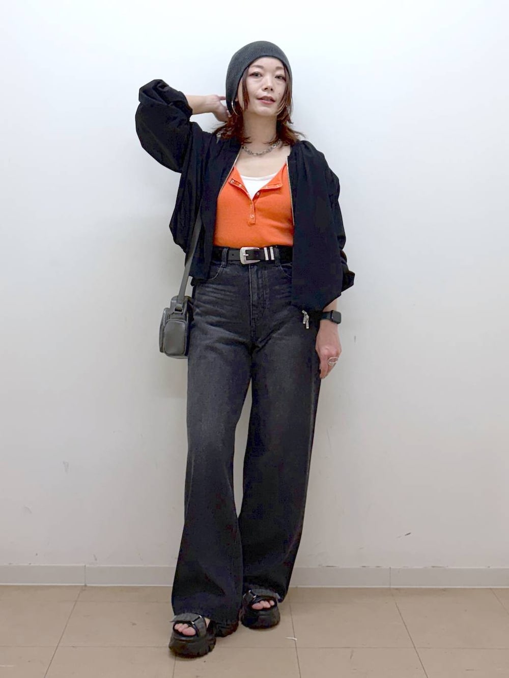 ホワイト系のキャミソール、ブラック系のデニムパンツ、ブラック系のブルゾンを着用したレディースの春コーディネートの9枚目の写真