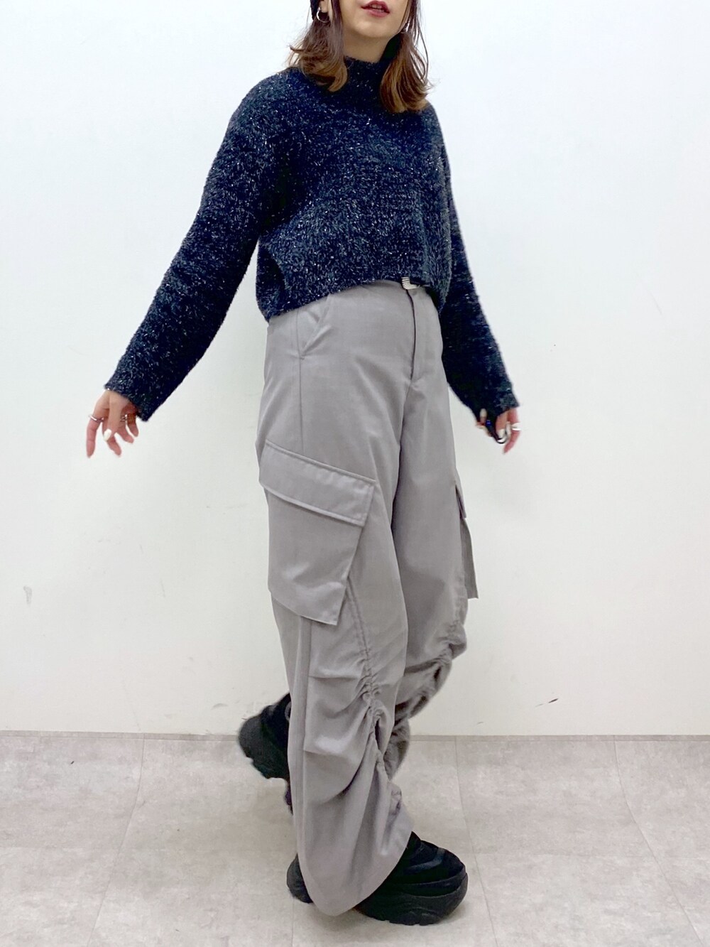 ブラック系のニット/セーター、ベージュ系のその他パンツ、ブラック系のスニーカーを着用したレディースの冬コーディネートの7枚目の写真
