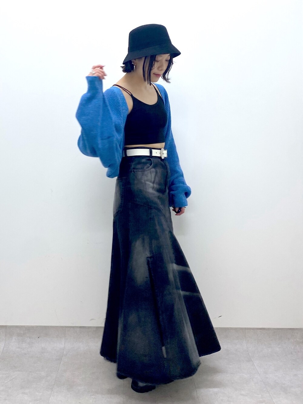 ブラック系のスカート、ブルー系のトップス、ブラック系のサンダルを着用したレディースの春コーディネートの4枚目の写真