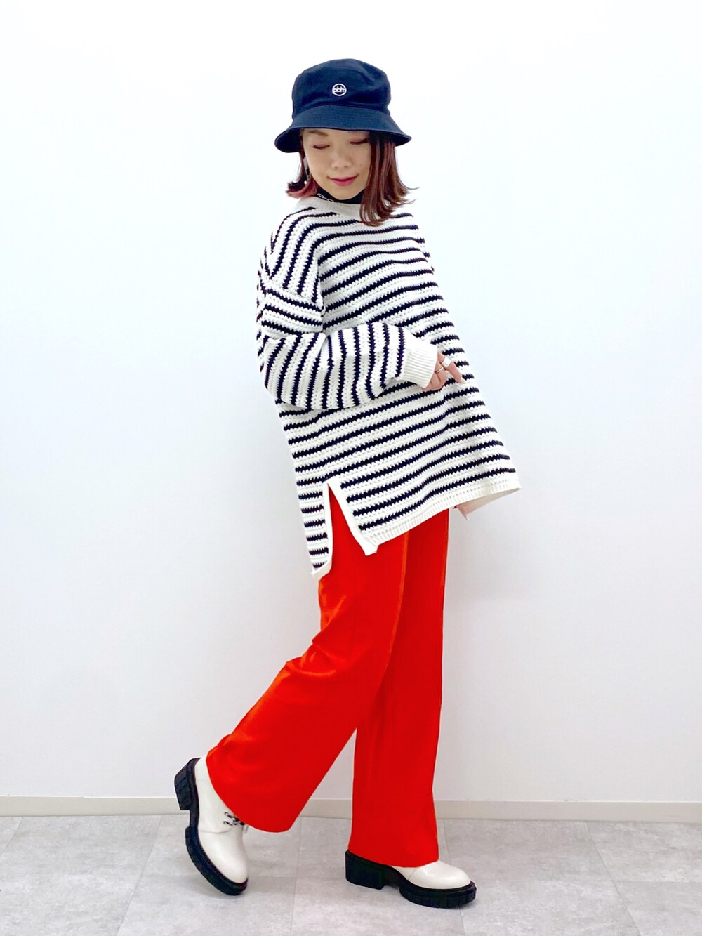 ホワイト系のニット/セーター、レッド系のスラックス、ホワイト系のローファーを着用したレディースの冬コーディネートの5枚目の写真