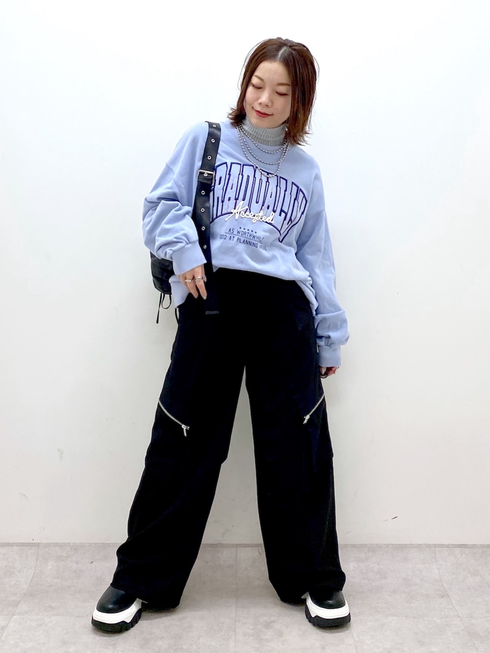 ブルー系のスウェット、ブラック系のカーゴパンツ、ブラック系のブーツを着用したレディースの冬コーディネートの9枚目の写真