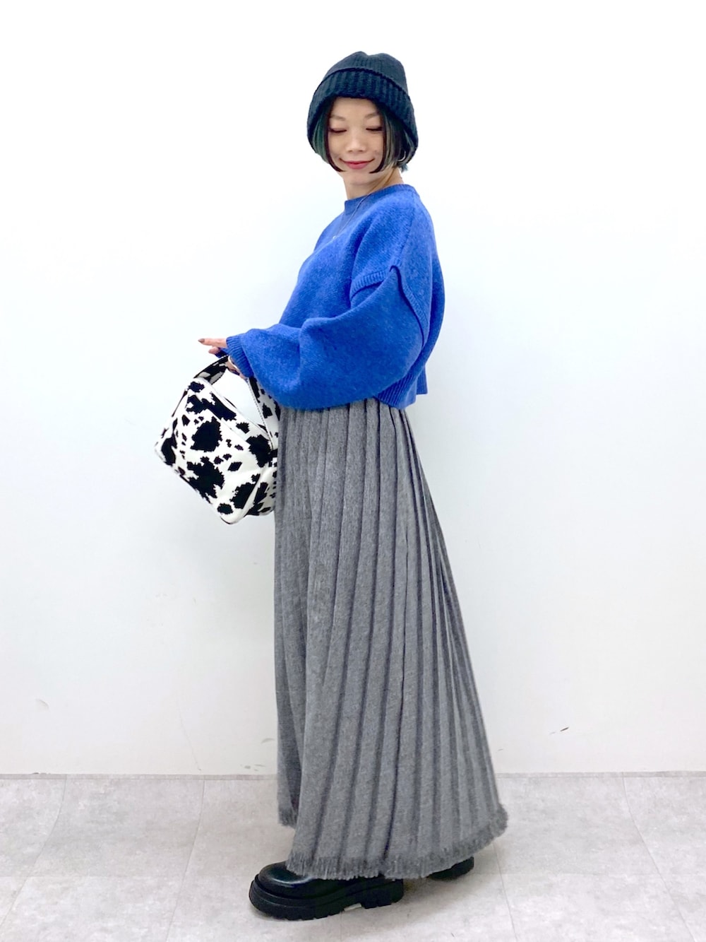 ブルー系のトップス、ブラック系のスカート、ブラック系のシューズを着用したレディースの秋コーディネートの2枚目の写真