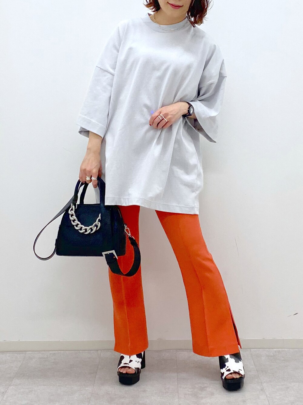 オレンジ系のその他パンツ、ホワイト系のサンダル、ブラック系のショルダーバッグを着用したレディースの春コーディネートの5枚目の写真