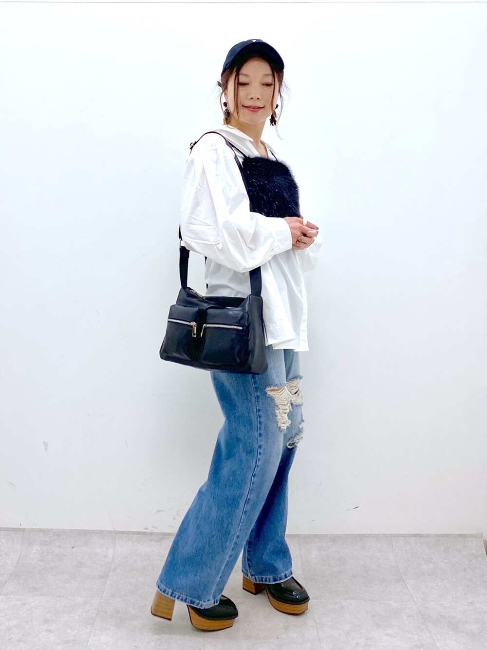ブルー系のデニムパンツ、ホワイト系のシャツ/ブラウス、ブラック系のベストを着用したレディースの秋コーディネートの3枚目の写真