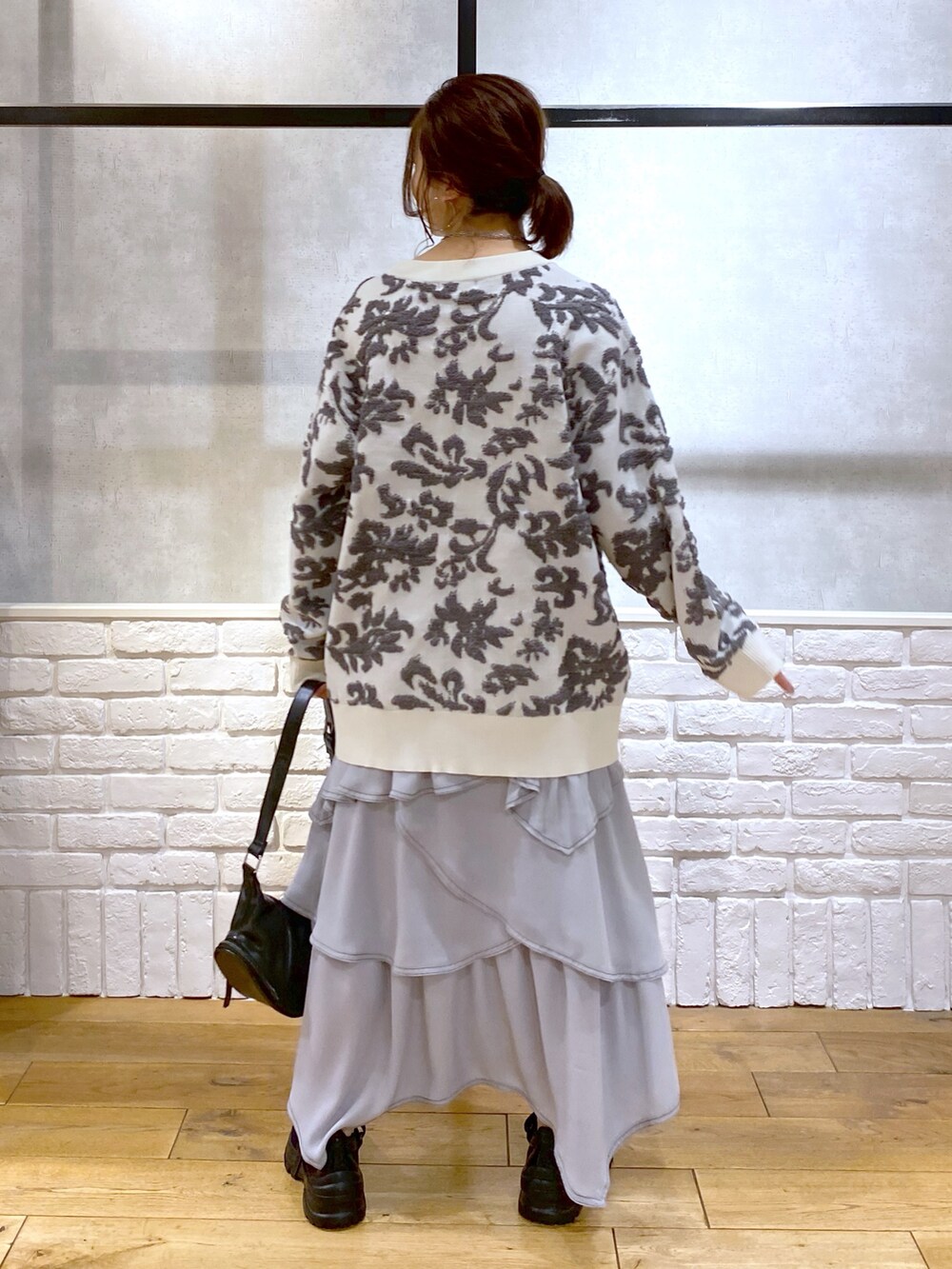 ブラック系のショルダーバッグ、ホワイト系のカーディガン/ボレロ、ホワイト系のキャミソールを着用したレディースの春コーディネートの6枚目の写真