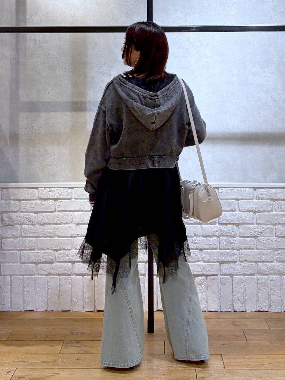 ブルー系のデニムパンツ、ホワイト系のボストンバッグ、ホワイト系のニット/セーターを着用したレディースの春コーディネートの6枚目の写真