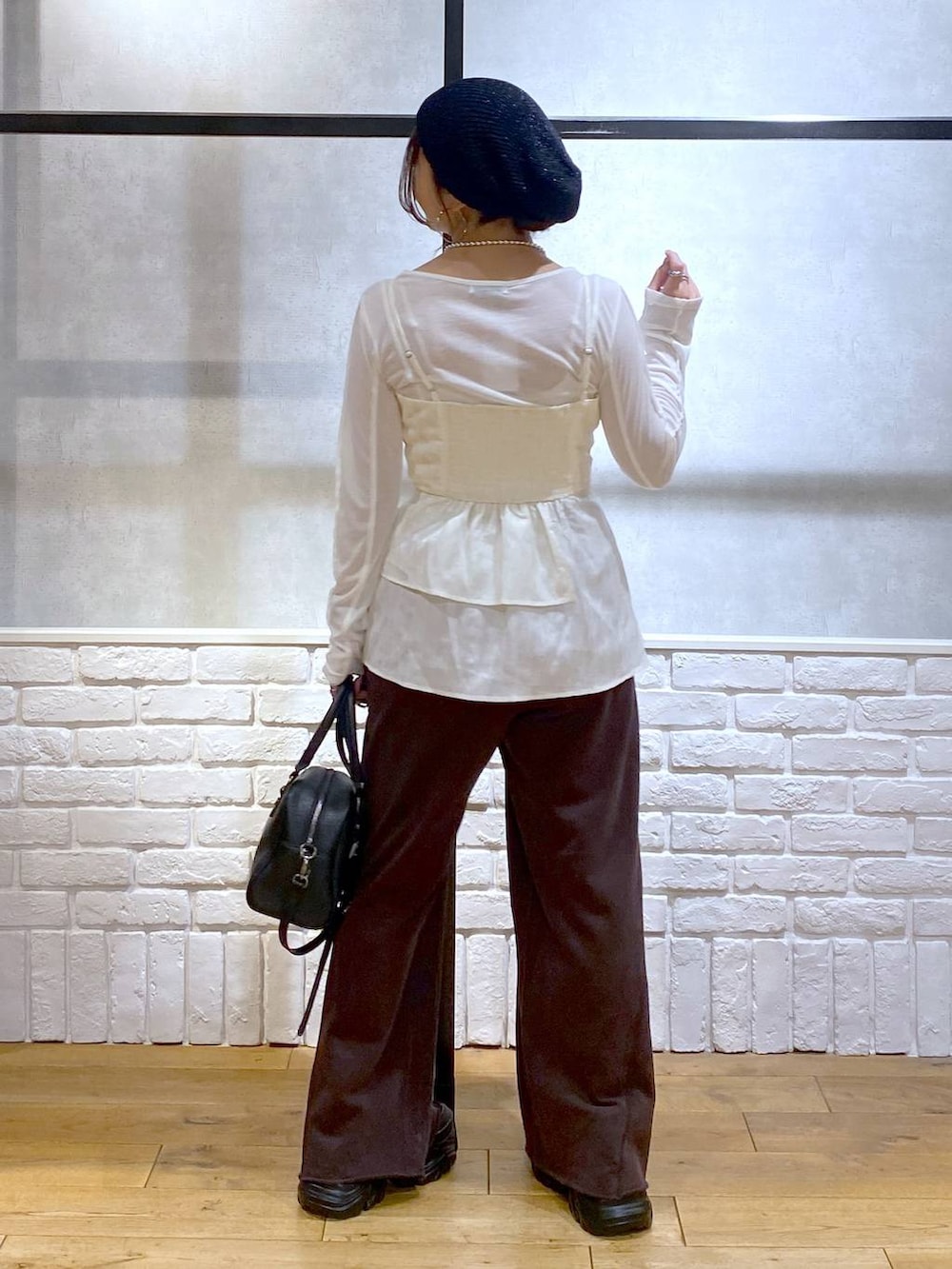 ブラック系のスニーカー、ブラック系のショルダーバッグ、ブラウン系のスウェットパンツを着用したレディースの秋コーディネートの6枚目の写真