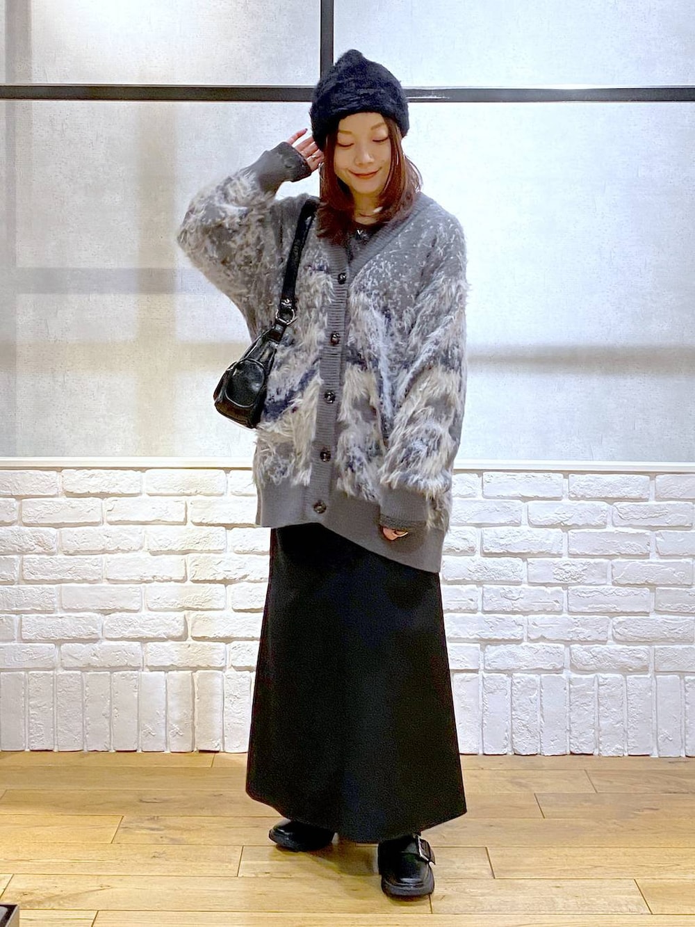 シルバー系のTシャツ/カットソー、ブラック系のブーツ、ブラック系のスカートを着用したレディースの冬コーディネートの8枚目の写真