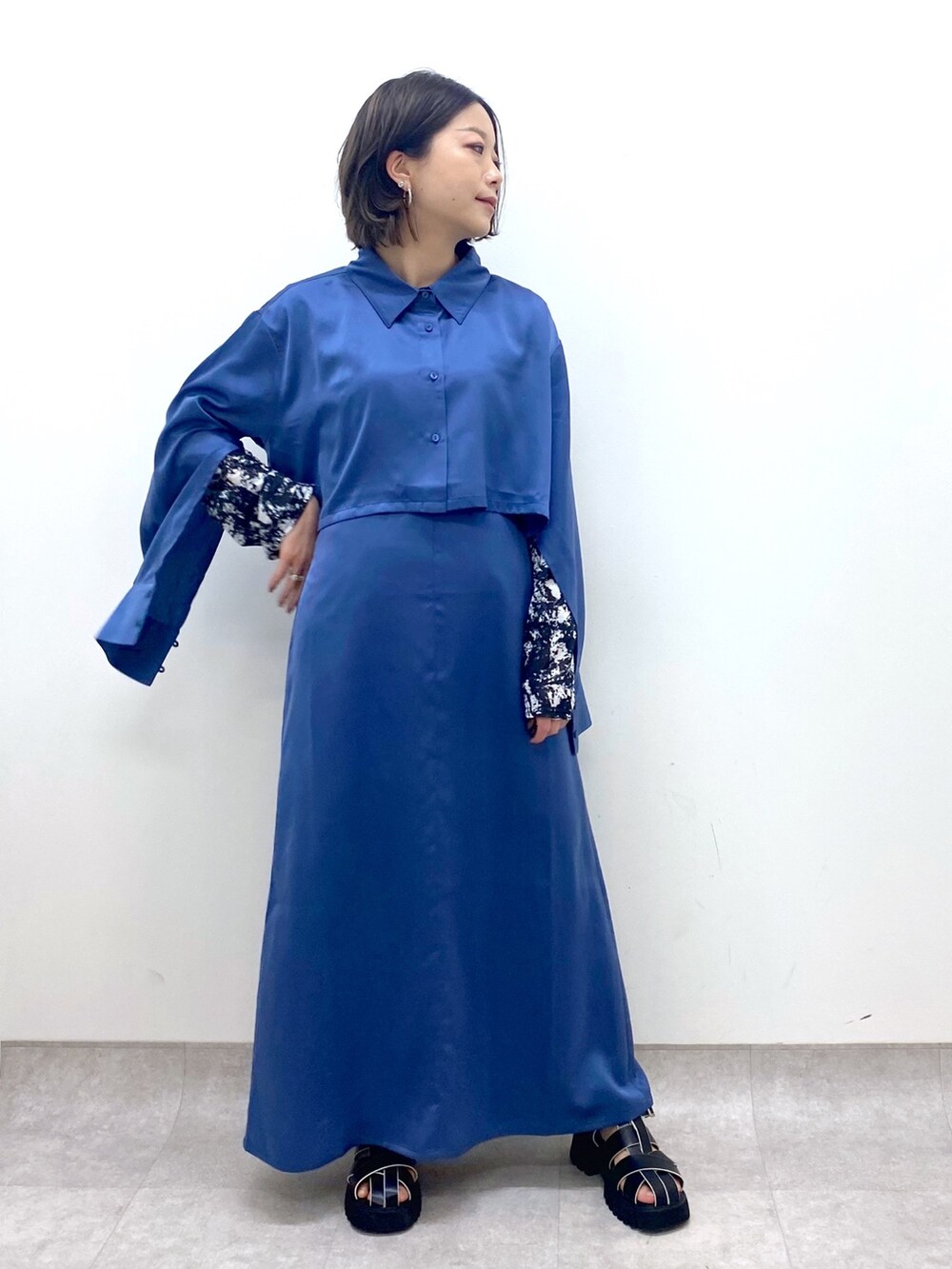 ブルー系のワンピース/ドレス、ブラック系のTシャツ/カットソー、ブラック系のサンダルを着用したレディースの春コーディネートの5枚目の写真