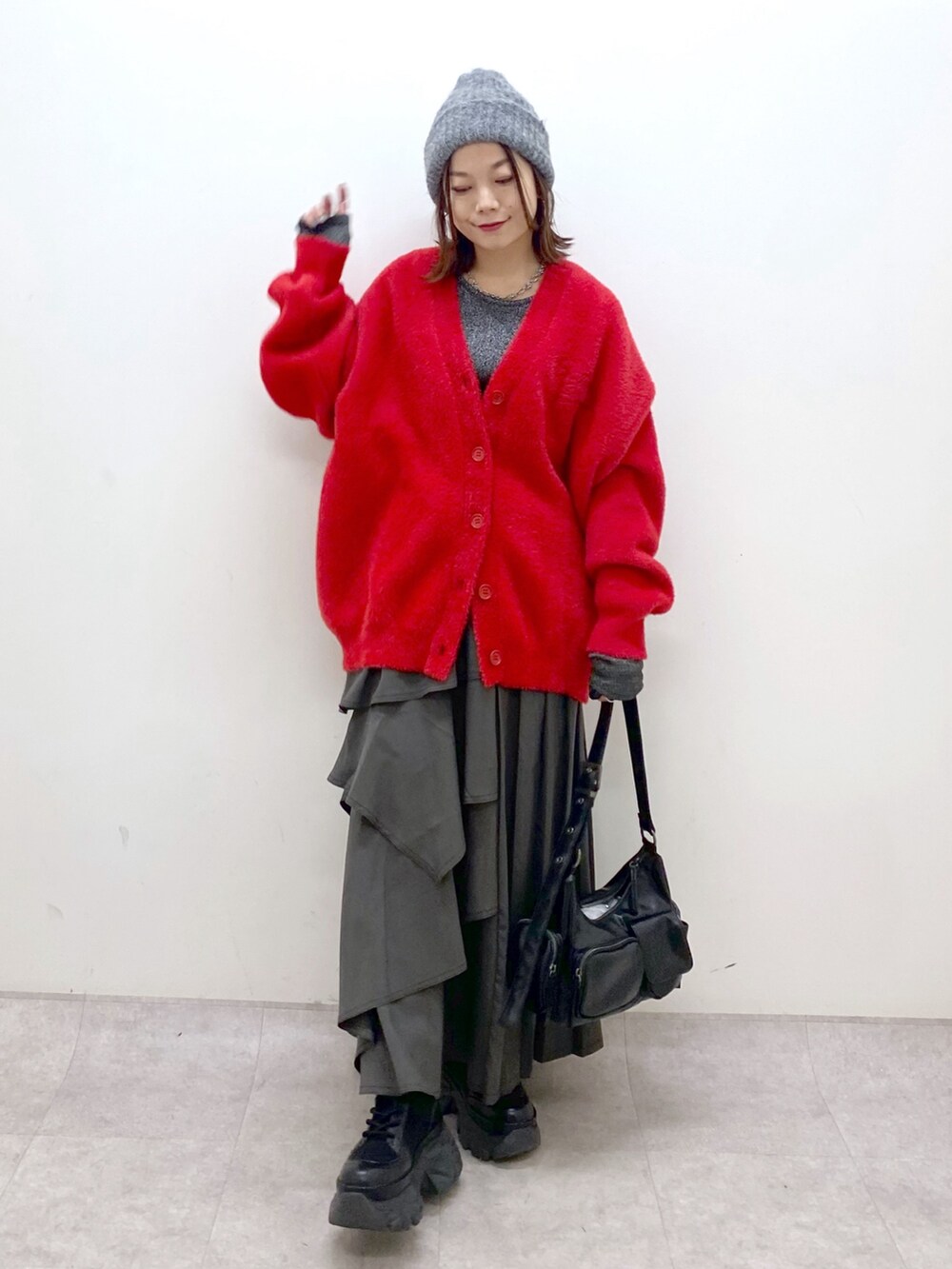 レッド系のカーディガン/ボレロ、シルバー系のTシャツ/カットソー、ブラウン系のスカートを着用したレディースの秋コーディネートの4枚目の写真