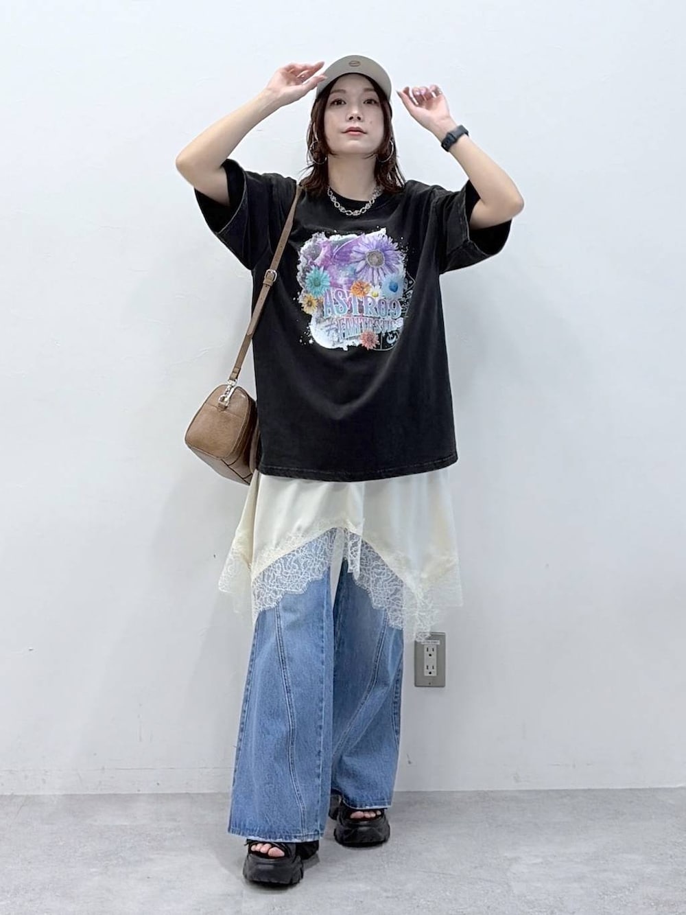 ブルー系のデニムパンツ、ブラウン系のボストンバッグ、ホワイト系のチュニックを着用したレディースの春コーディネートの9枚目の写真