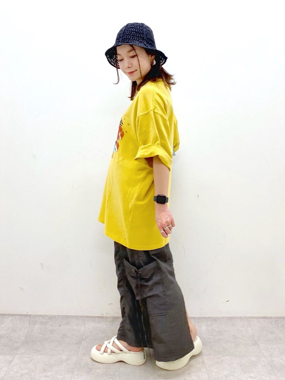 グレー系のスカート、ホワイト系のサンダル、ブルー系のハンドバッグを着用したレディースの春コーディネートの5枚目の写真