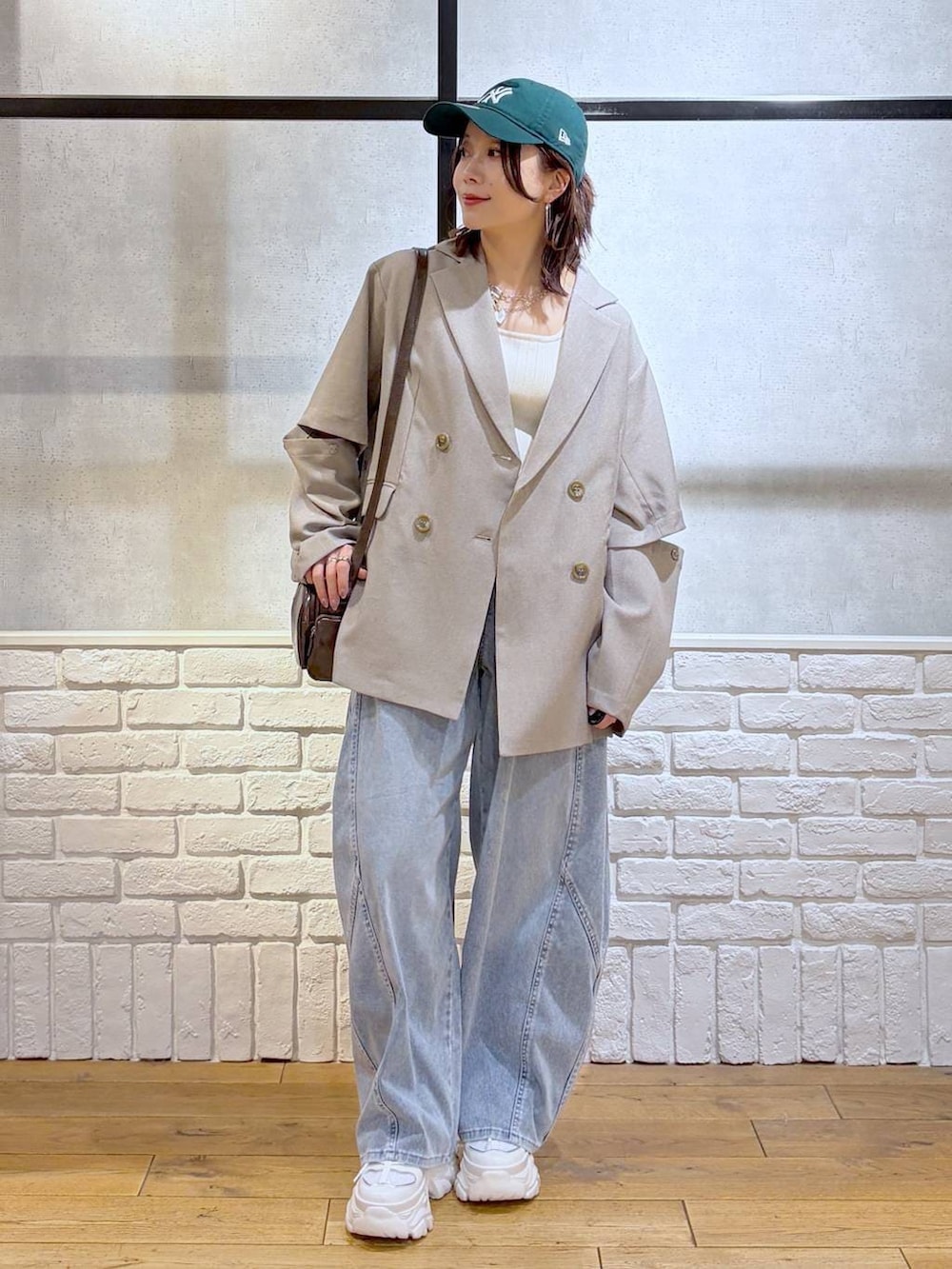 ホワイト系のスニーカー、ホワイト系のタンクトップ、ブラウン系のショルダーバッグを着用したレディースの春コーディネートの4枚目の写真