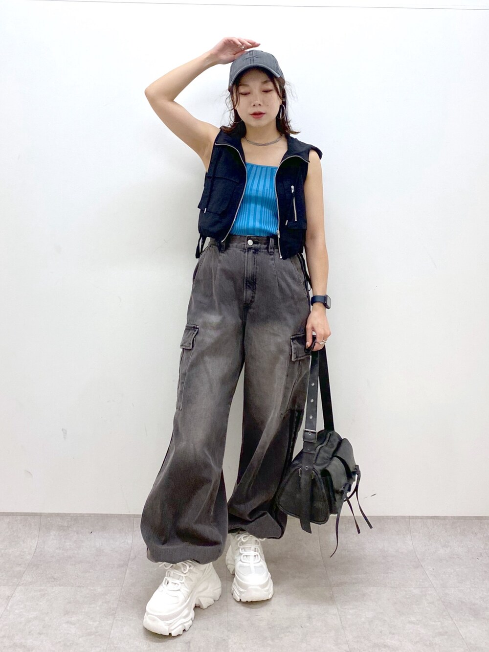 ブラウン系のデニムパンツ、ブラック系のショルダーバッグ、ホワイト系のスニーカーを着用したレディースの夏コーディネートの4枚目の写真