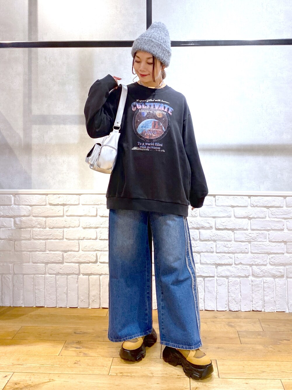 グレー系のスウェット、ブルー系のデニムパンツ、ブラウン系のブーツを着用したレディースの冬コーディネートの8枚目の写真