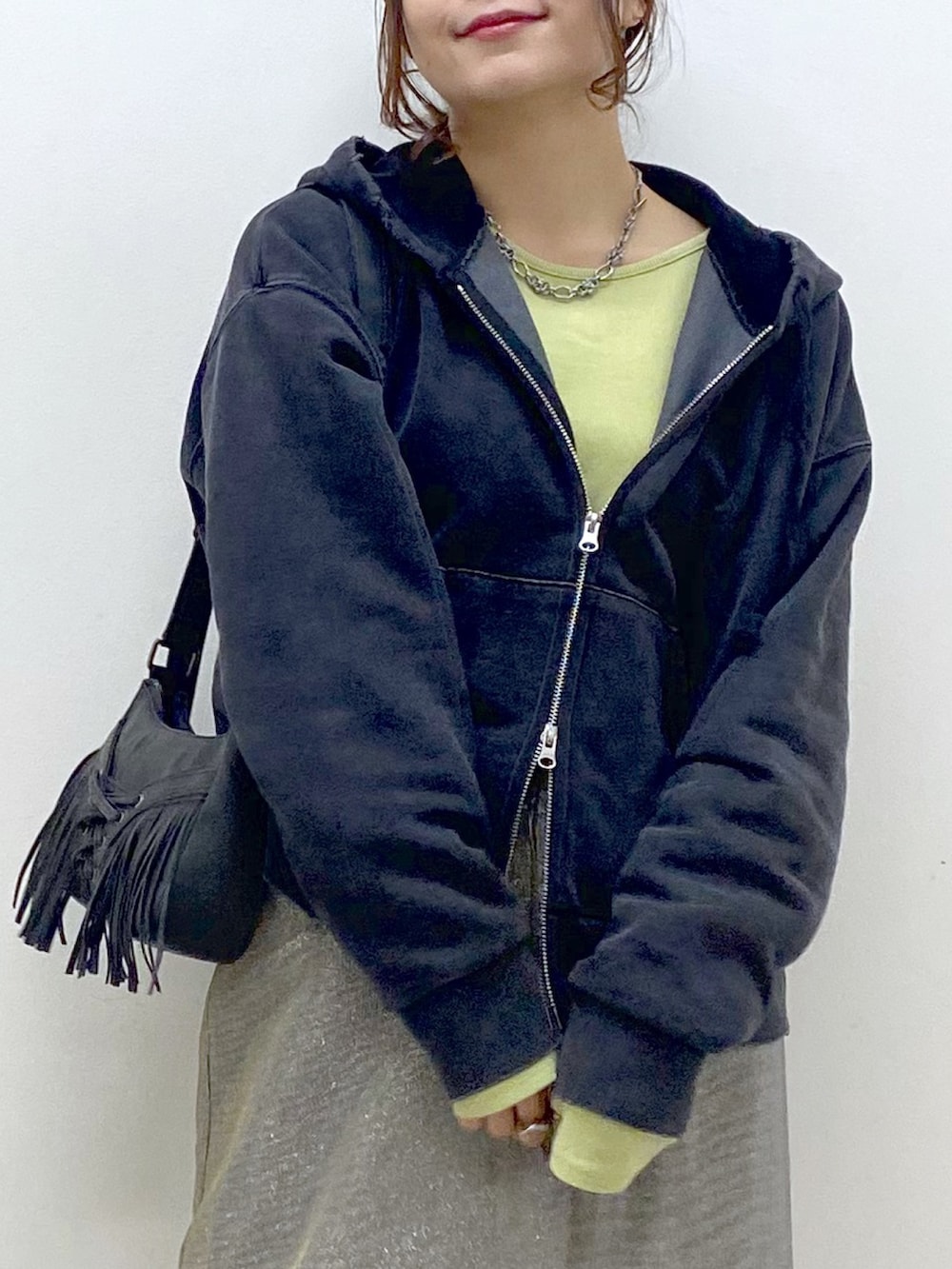 イエロー系のTシャツ/カットソー、ブラック系のパーカー、グレー系のスカートを着用したレディースの春コーディネートの2枚目の写真