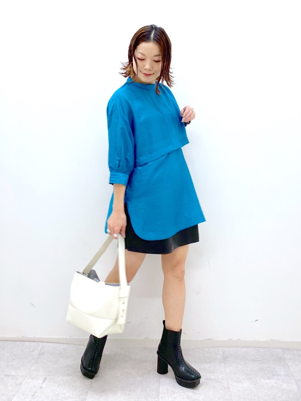 ブルー系のシャツ/ブラウス、ブラック系のパンツ、ホワイト系のバッグを着用したレディースの夏コーディネートの2枚目の写真