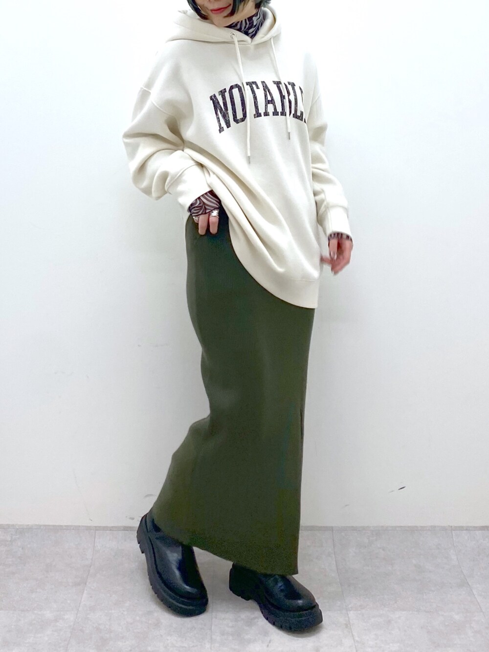 ホワイト系のパーカー、ブラック系のトップス、ブラック系のシューズを着用したレディースの秋コーディネートの5枚目の写真