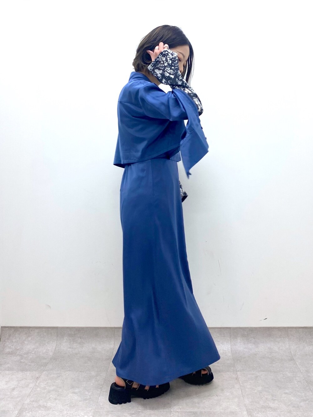 ブルー系のワンピース/ドレス、ブラック系のTシャツ/カットソー、ブラック系のサンダルを着用したレディースの春コーディネートの2枚目の写真