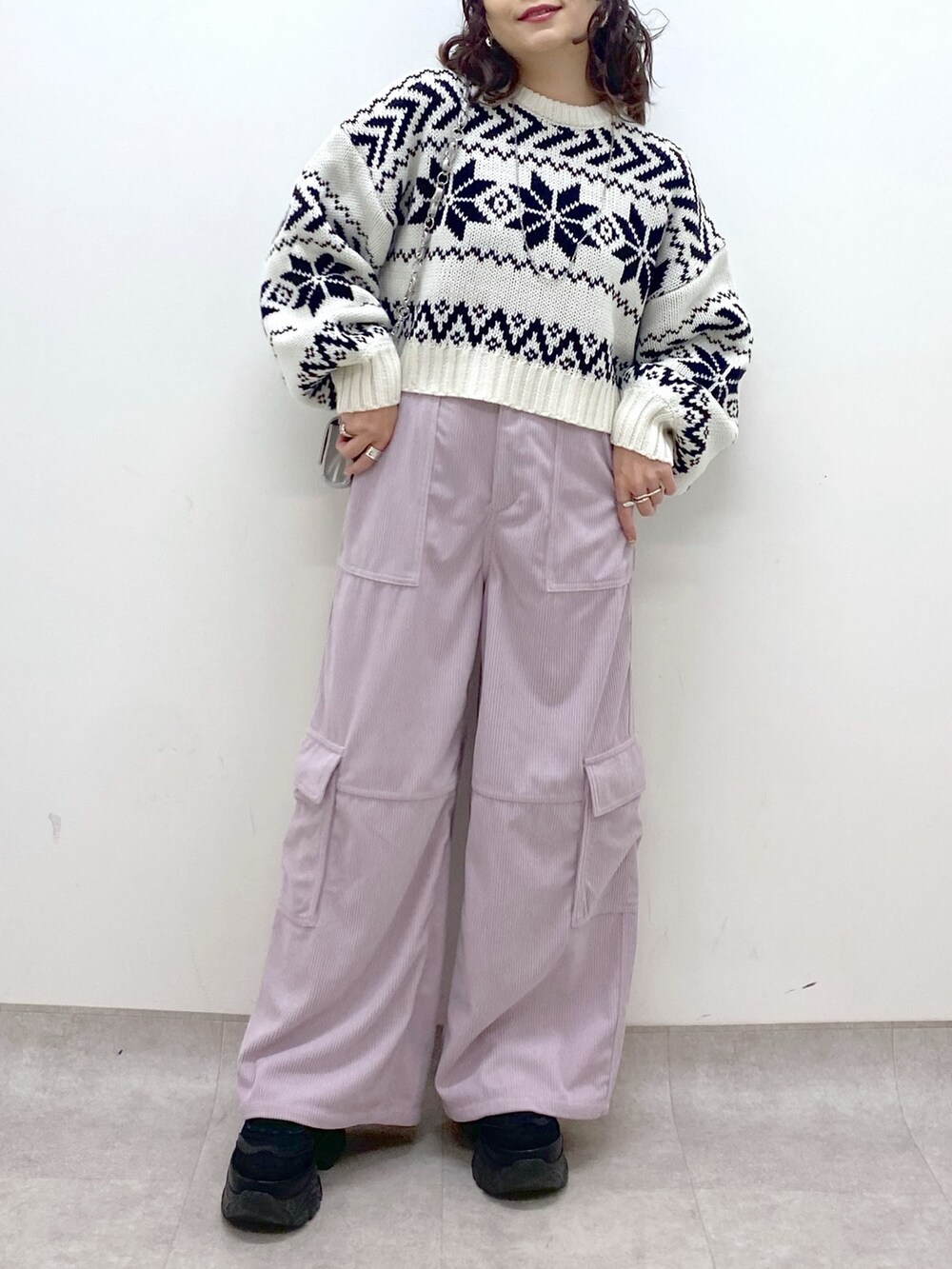 ピンク系のカーゴパンツ、ホワイト系のニット/セーター、シルバー系のショルダーバッグを着用したレディースの冬コーディネートの8枚目の写真