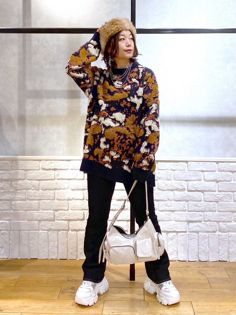 ブルー系のニット/セーター、ブルー系のデニムパンツ、ホワイト系のショルダーバッグを着用したレディースの冬コーディネートの4枚目の写真