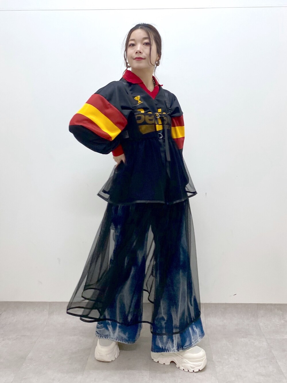 ブラック系のシャツ/ブラウス、ブラック系のワンピース、ブルー系のデニムパンツを着用したレディースの春コーディネートの4枚目の写真