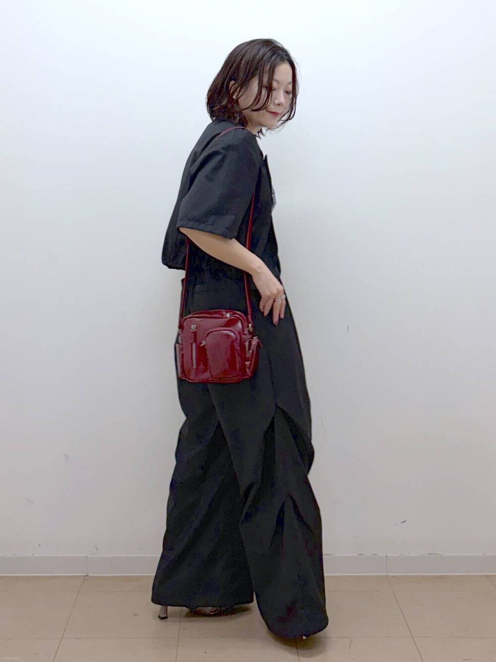 ブラック系のTシャツ/カットソー、レッド系のショルダーバッグ、その他のサンダルを着用したレディースの夏コーディネートの5枚目の写真