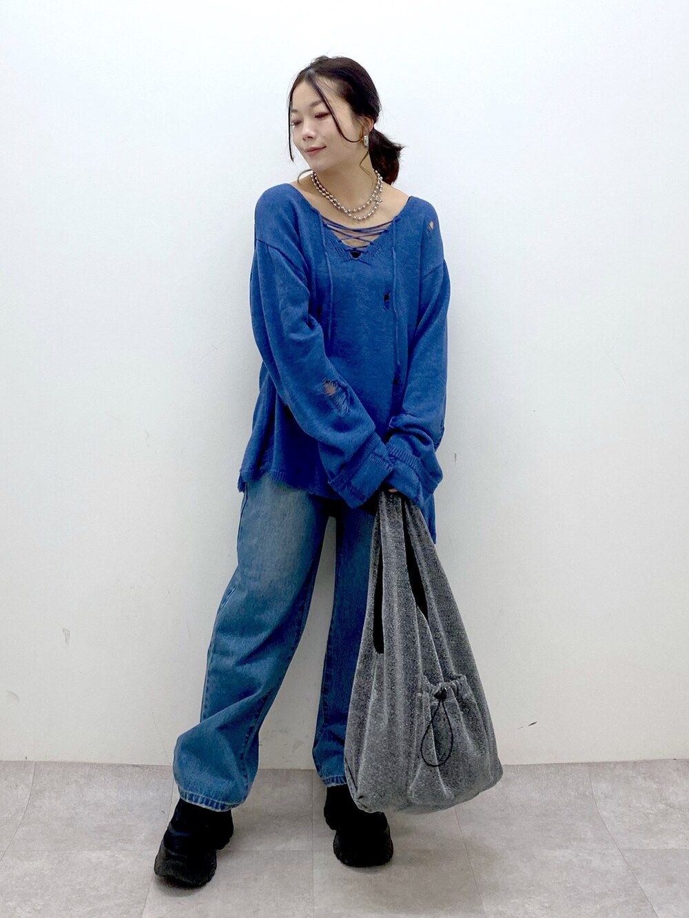 ブルー系のニット/セーター、ブルー系のデニムパンツ、ブラック系のトートバッグを着用したレディースの冬コーディネートの9枚目の写真