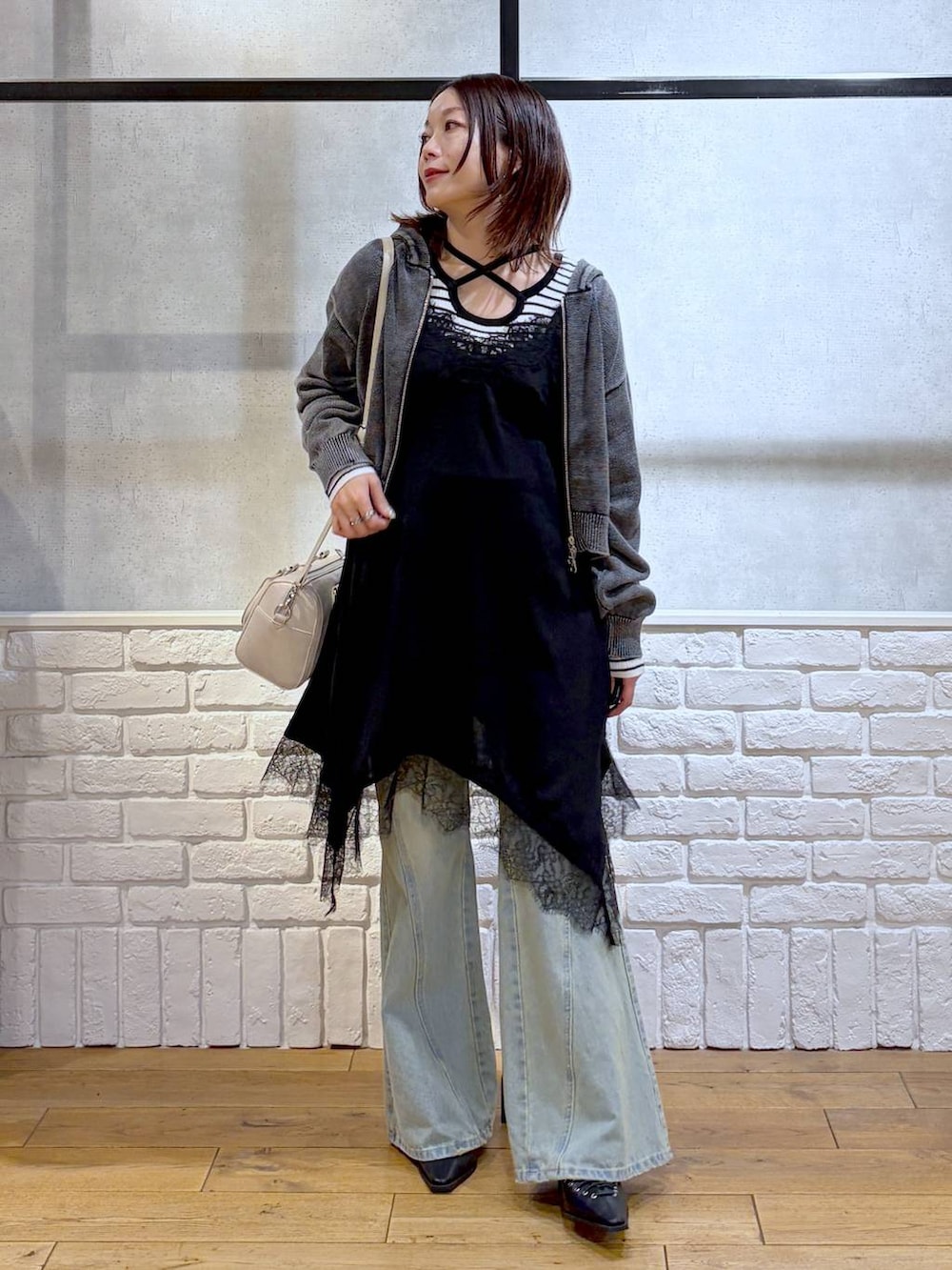 ブルー系のデニムパンツ、ホワイト系のボストンバッグ、ホワイト系のニット/セーターを着用したレディースの春コーディネートの4枚目の写真