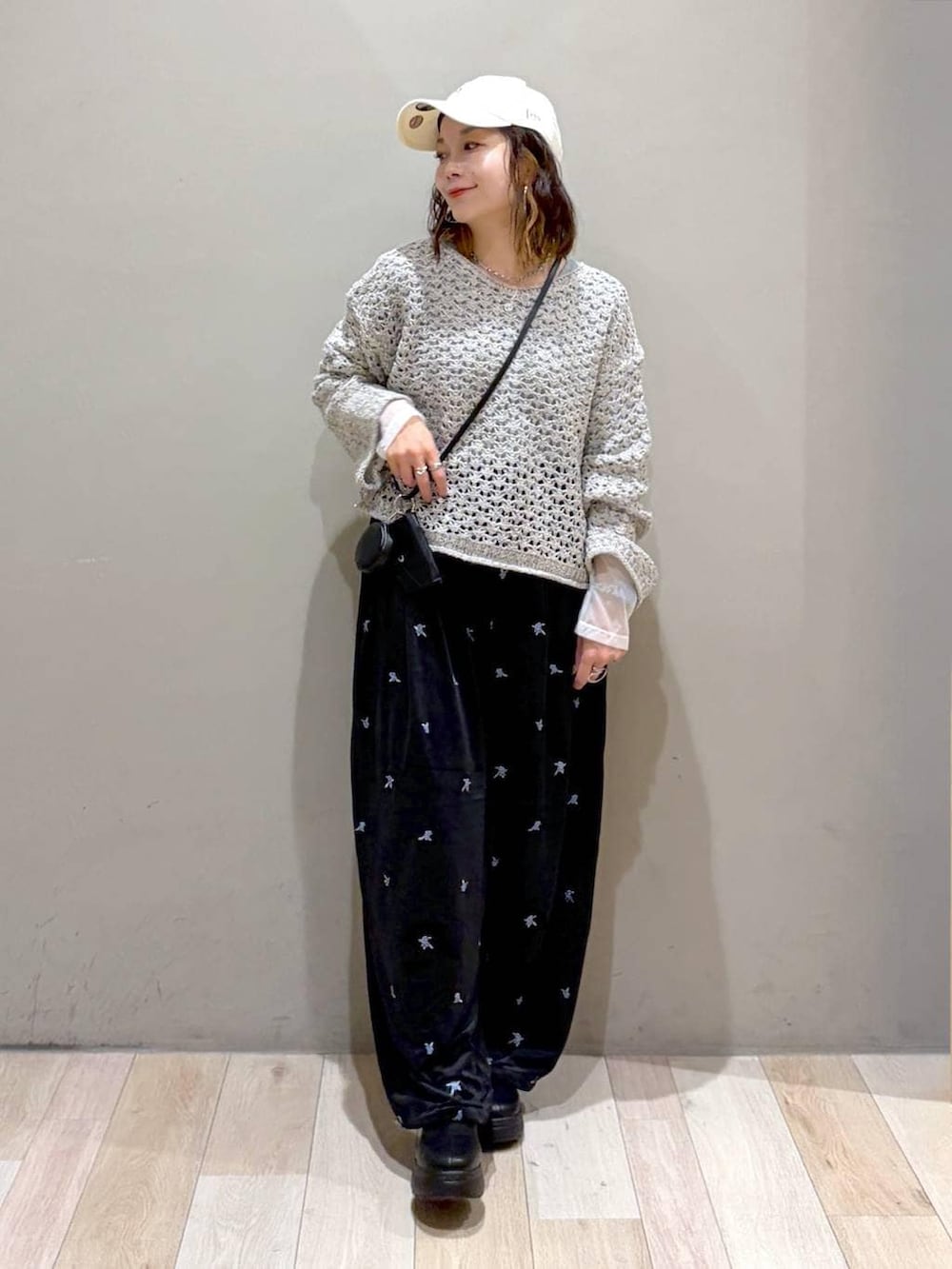 ブラック系のその他パンツ、ブラック系のブーツ、ホワイト系のニット/セーターを着用したレディースの秋コーディネートの4枚目の写真