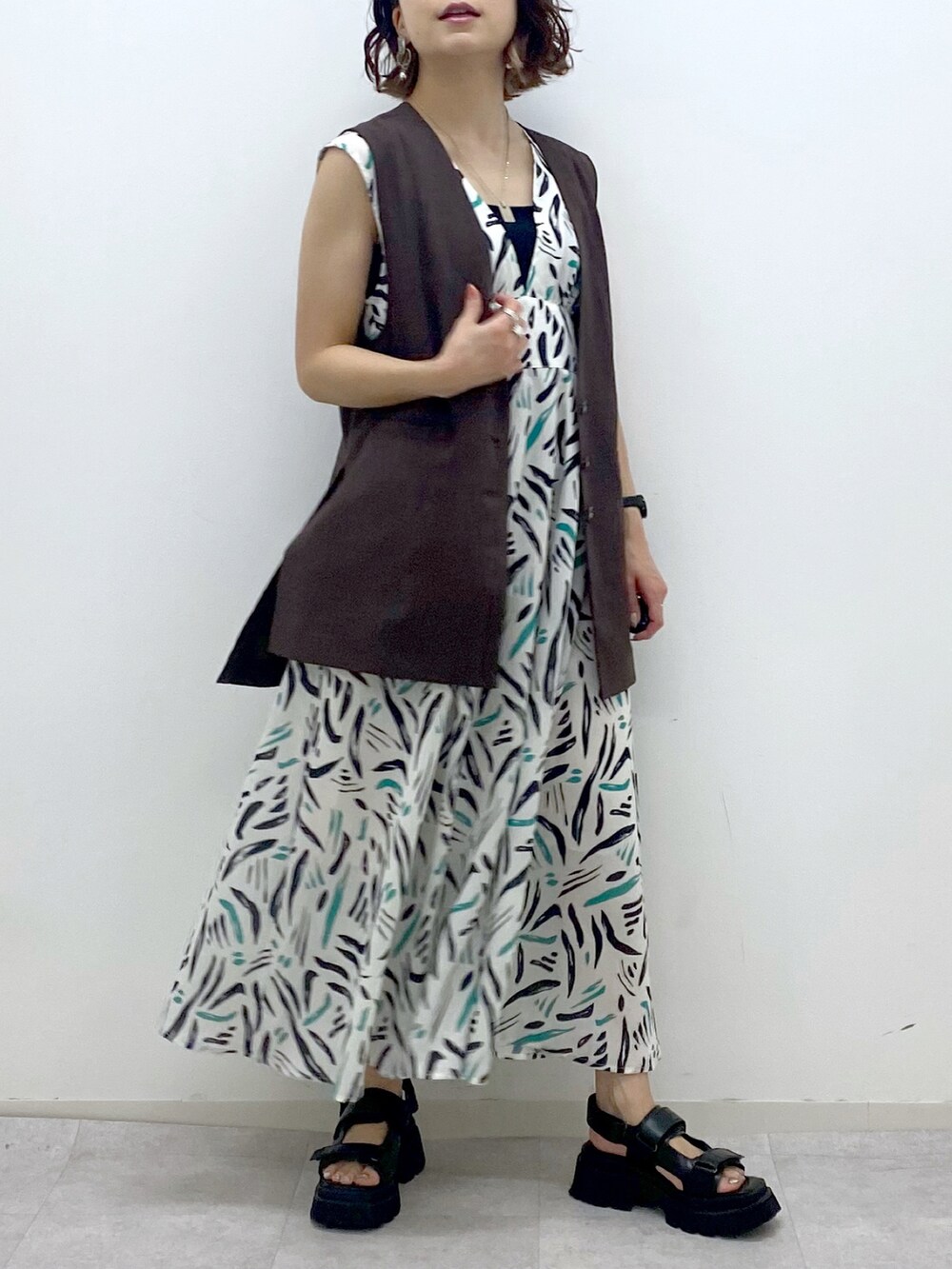 ホワイト系のワンピース、ブラウン系のその他アウター、ブラック系のサンダルを着用したレディースの夏コーディネートの5枚目の写真