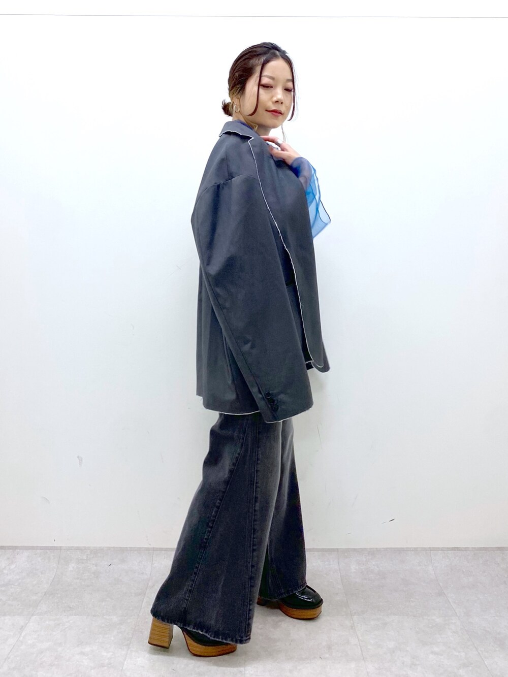 グレー系のテーラードジャケット、ブルー系のシャツ/ブラウス、ブラック系のデニムパンツを着用したレディースの秋コーディネートの4枚目の写真