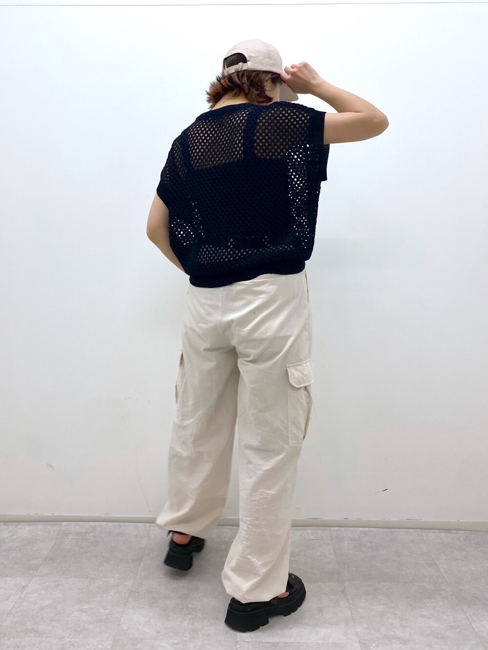 ホワイト系のカーゴパンツ、ブラック系のトップス、ブラック系のサンダルを着用したレディースの夏コーディネートの3枚目の写真