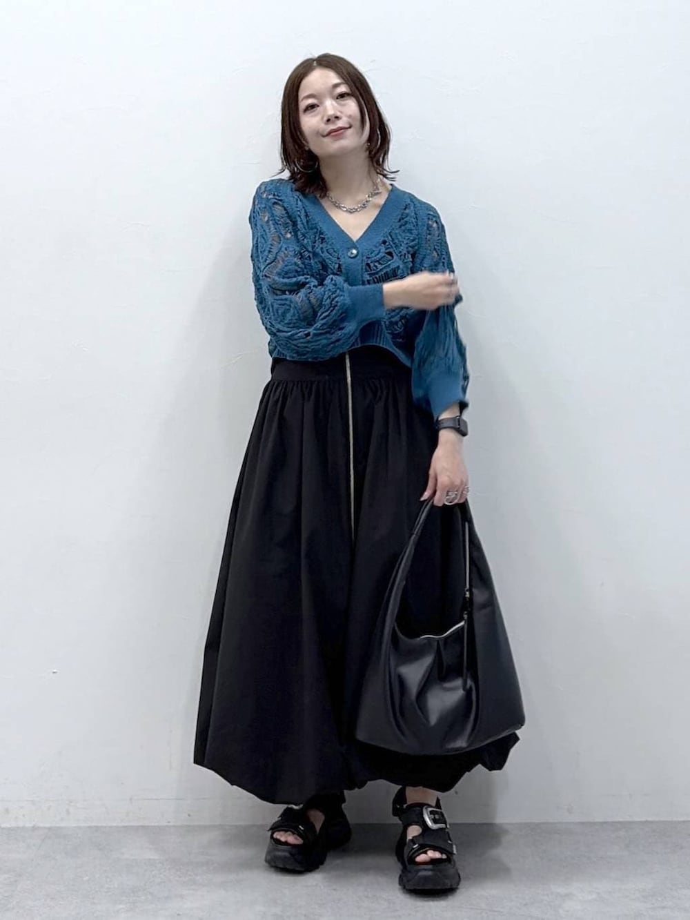 ブルー系のカーディガン/ボレロ、ブラック系のスカートを着用したレディースの春コーディネートの8枚目の写真
