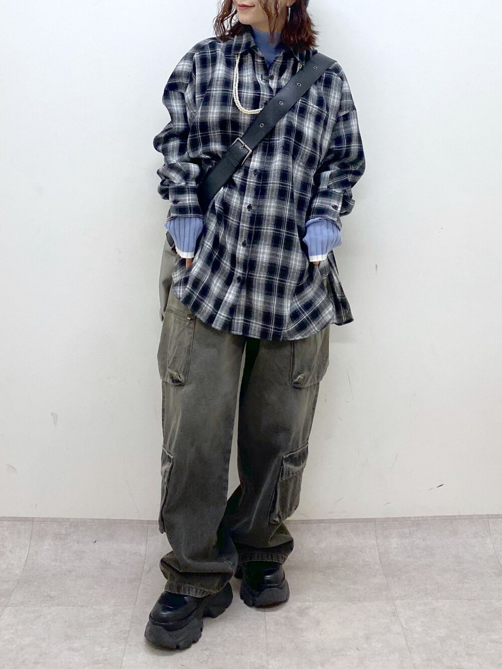 ブラック系のシャツ/ブラウス、シルバー系のトートバッグ、ブルー系のニット/セーターを着用したレディースの冬コーディネートの3枚目の写真