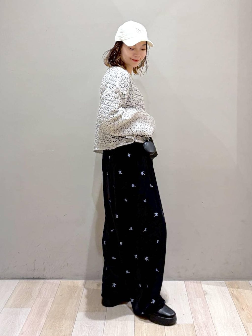 ブラック系のその他パンツ、ブラック系のブーツ、ホワイト系のニット/セーターを着用したレディースの秋コーディネートの7枚目の写真