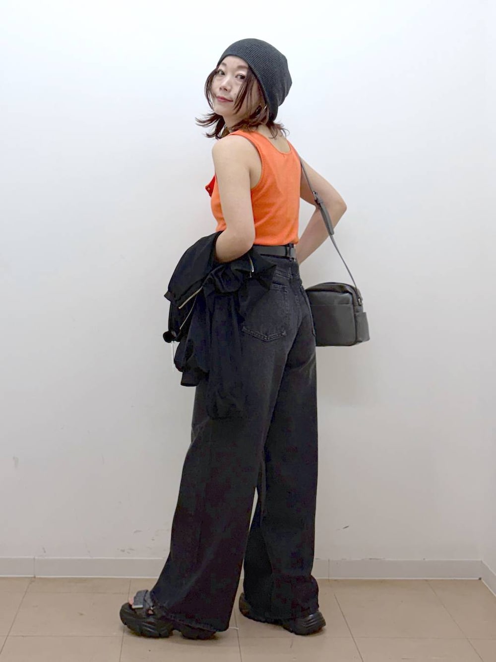 ホワイト系のキャミソール、ブラック系のデニムパンツ、ブラック系のブルゾンを着用したレディースの春コーディネートの4枚目の写真
