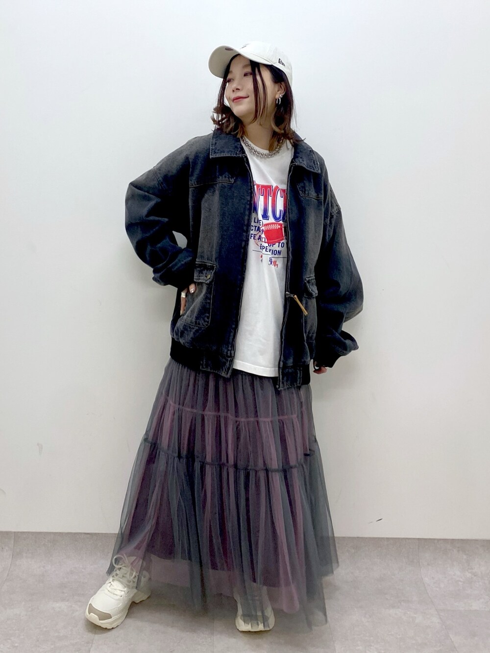 ホワイト系のTシャツ/カットソー、ブラック系のデニムジャケット、グレー系のスカートを着用したレディースの冬コーディネートの4枚目の写真