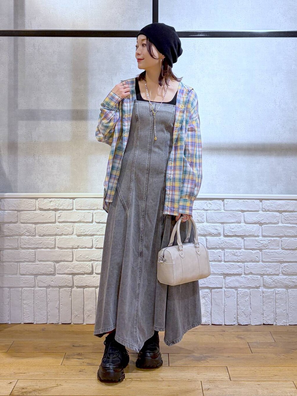 ブラック系のスニーカー、ホワイト系のボストンバッグ、ブラック系のワンピースを着用したレディースの春コーディネートの8枚目の写真