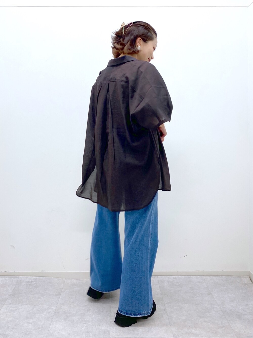 ブルー系のパンツ、イエロー系のタンクトップ、ベージュ系のショルダーバッグを着用したレディースの夏コーディネートの3枚目の写真