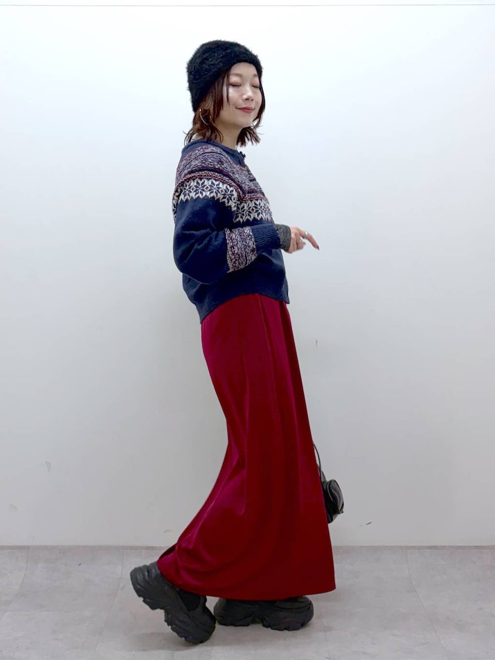 ブラック系のブーツ、シルバー系のTシャツ/カットソー、ブラック系のショルダーバッグを着用したレディースの冬コーディネートの5枚目の写真