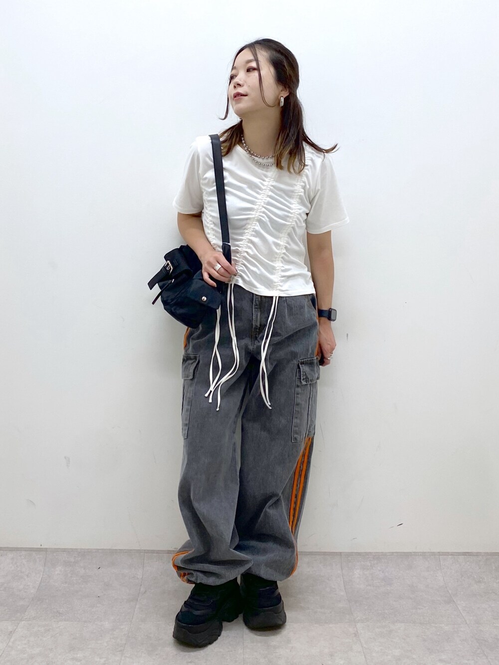 ホワイト系のTシャツ/カットソー、ブラック系のデニムパンツ、ブラック系のスニーカーを着用したレディースの春コーディネートの9枚目の写真