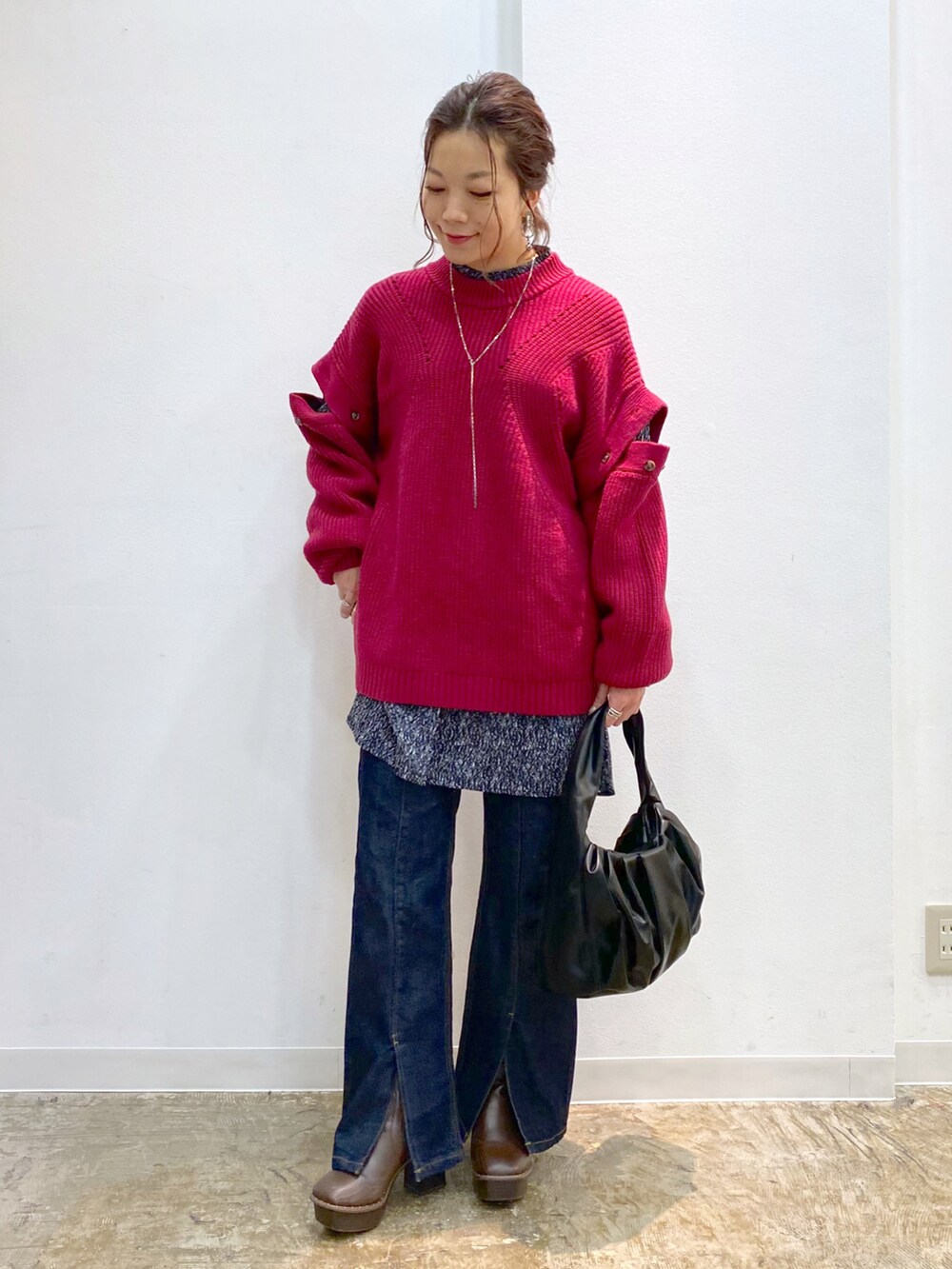 ピンク系のニット/セーター、ブラック系のTシャツ/カットソー、ブラック系のハンドバッグを着用したレディースの秋コーディネートの3枚目の写真