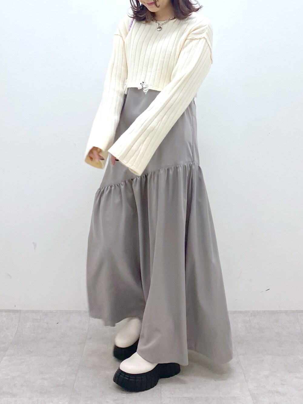 ホワイト系のワンピース、ピンク系のショルダーバッグ、ホワイト系のブーツを着用したレディースの冬コーディネートの6枚目の写真