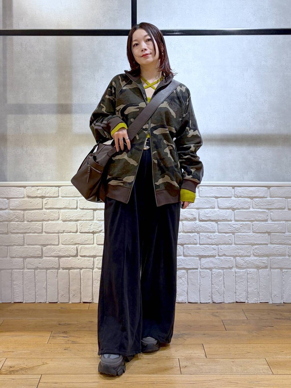 グレー系のスニーカー、ブラウン系のボストンバッグ、イエロー系のニット/セーターを着用したレディースの冬コーディネートの8枚目の写真