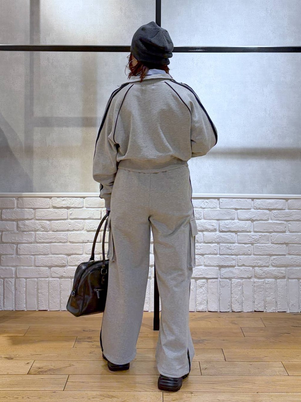 ブラック系のブーツ、ブラック系のボストンバッグ、グレー系のジャージを着用したレディースの冬コーディネートの5枚目の写真