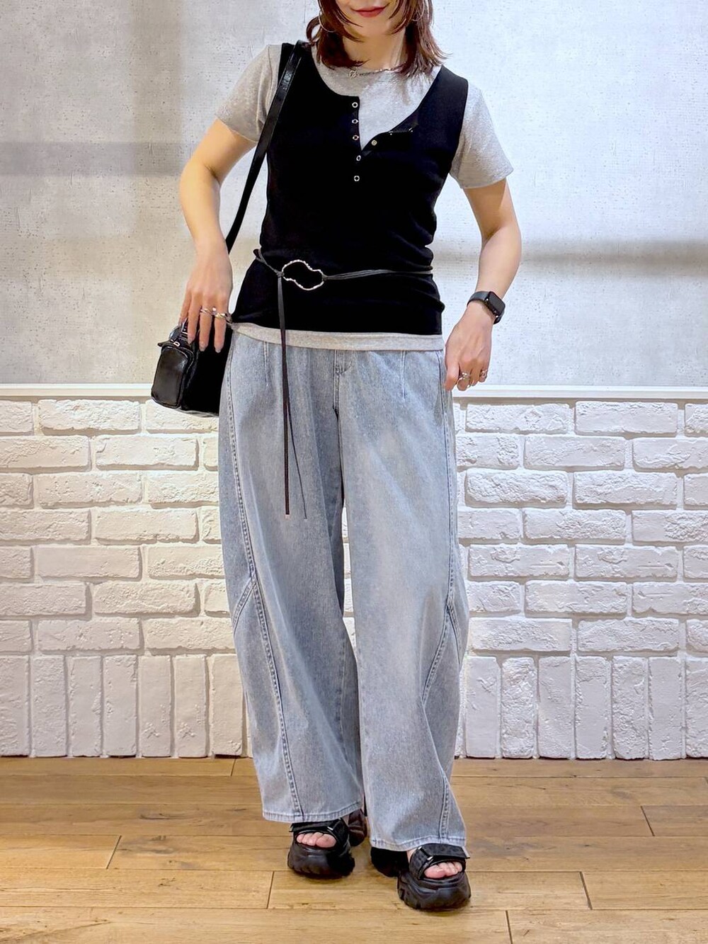 ブルー系のデニムパンツ、ブラック系のショルダーバッグ、ブラック系のサンダルを着用したレディースの春コーディネートの2枚目の写真